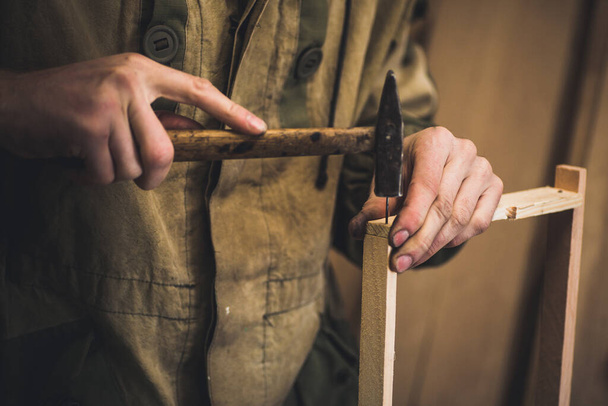 L'homme colle un cadre en bois pour les abeilles. Les mains des hommes avec de longs doigts minces tiennent cadre en bois. - Photo, image