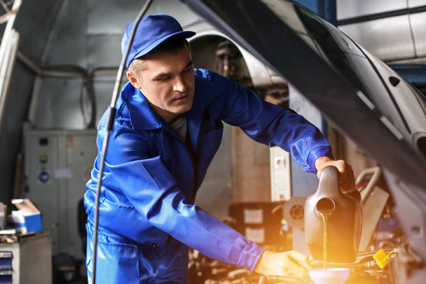 Mužské mechanik doplňování oleje auto v servise - Fotografie, Obrázek