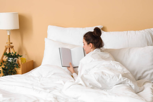 Утро молодой женщины, читающей книгу в постели - Фото, изображение