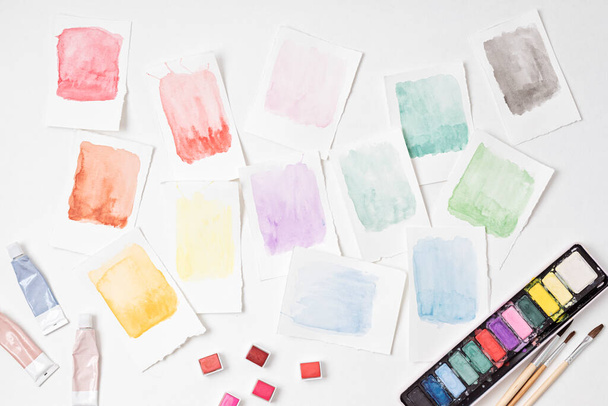Artysta malarstwo palety akwareli w pastelowych kolorach z pędzlami. Twórczość artystyczna. Pocieszające, stresujące hobby, terapia plastyczna - Zdjęcie, obraz