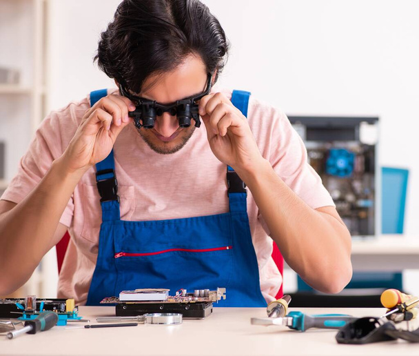 The young male contractor repairing computer - Foto, immagini