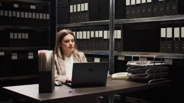 In the evidence room, caucasian law officer analyzes case files and exchanges information with african american male inspector. Multiethnic law enforcement agents discussing criminal investigations. - Footage, Video