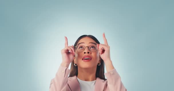 Happy, face and woman pointing up in studio with platform, agreement or promotion on blue background. Smile, portrait and excited female model with emoji hands for branding, support or service info. - Footage, Video