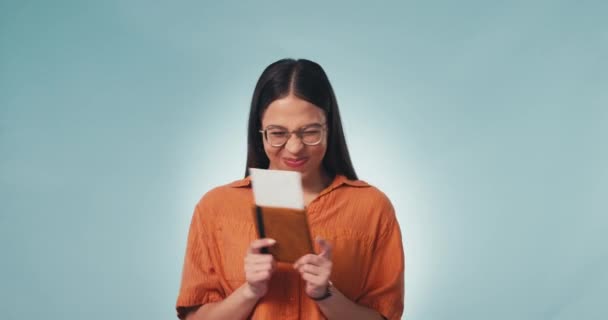 Woman, smile and excited with plane ticket in hands, contest and win for vacation. Winner person, travel and flight to destination, happy and goofy to getaway, studio and portrait by blue background. - Footage, Video