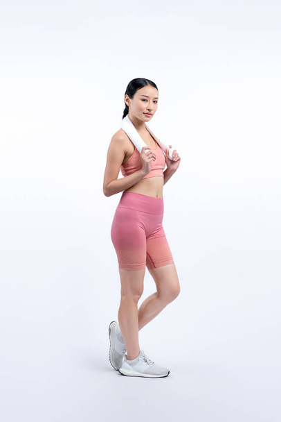 Spor giyim portresindeki tüm vücut Asyalı kadın gülümsüyor ve neşeli bir jest yapıyor. Çekici bir kızla egzersiz yapmak sağlıklı yaşam tarzını sürdürmeye yöneliktir. İzole edilmiş arka plan Vigorous - Fotoğraf, Görsel