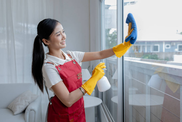Mulher asiática equipe de limpeza, limpeza de janelas da governanta em um escritório da empresa, mantendo a limpeza no escritório. Conceito de limpeza e governanta cuidando da limpeza e ordem no escritório - Foto, Imagem