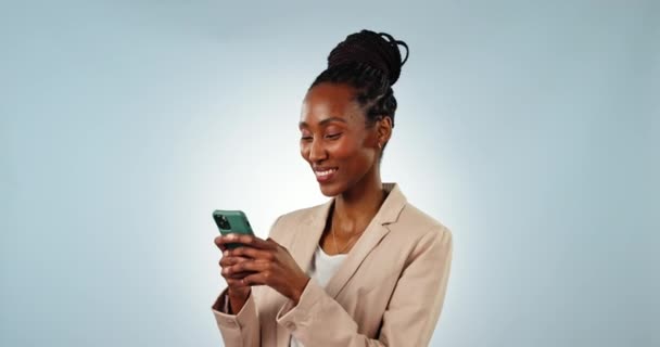 Telefon, mosoly és fekete nő egy stúdióban, aki üzenetet ír a közösségi médián, a mobilalkalmazáson vagy az interneten. Happy, technológia és fiatal afrikai női modell hálózatépítés mobiltelefon elszigetelt szürke háttér. - Felvétel, videó