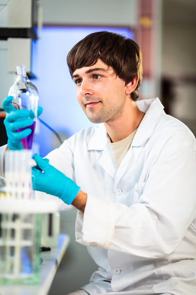 joven investigador masculino que realiza investigación científica en un laboratorio - Foto, imagen