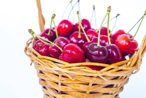 cherries in a wicker basket isolated on white background - Photo, Image