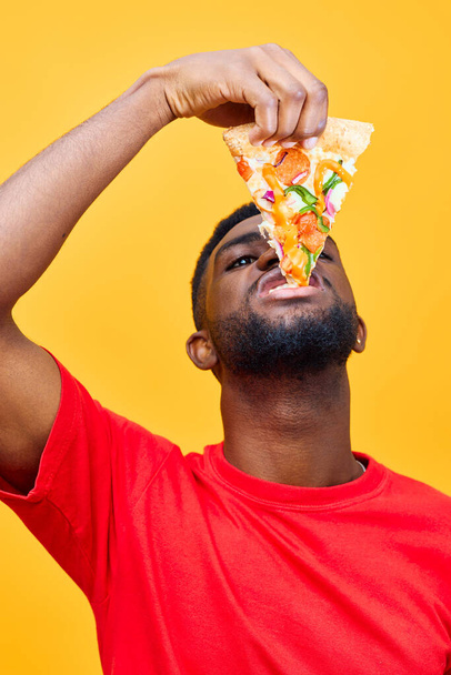 american man meal lifestyle delivery red food weight dieting overeating background black cheerful happy smile person online pizza fast slice hungry food african guy - Foto, immagini