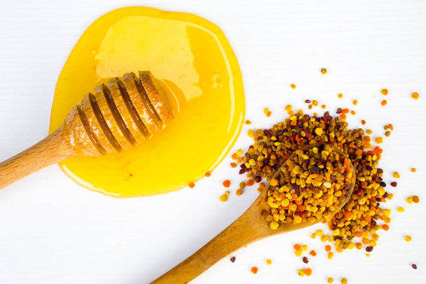 Luonnollinen hunaja ja mehiläinen siitepöly eristetty valkoisella pohjalla
 - Valokuva, kuva