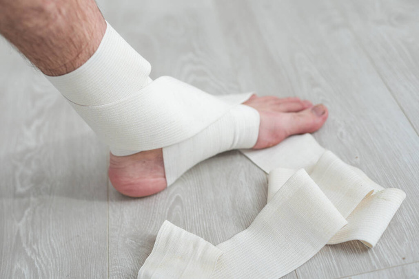 homem usando colocar em bandagem elástica com pernas com dor nas pernas. - Foto, Imagem
