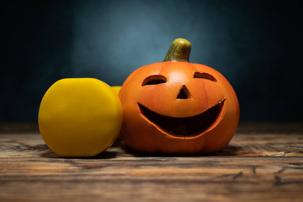 Kis kerámia Halloween Jack-o '-lámpás kísérteties figura tök és sárga súlyzó. Egészséges fitness életmód ősszel vagy ősszel kompozíció. Tornaterem edzés és sport edzés koncepció. - Fotó, kép
