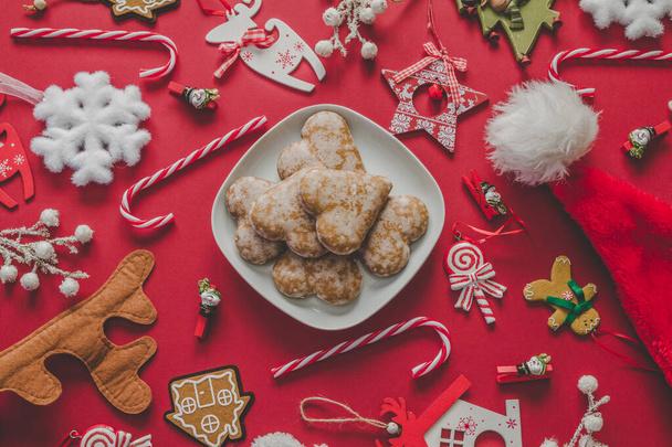 Na vánočním stolku ležela kompozice. Lahodné perníkové sušenky ve tvaru srdce, cukrové tyčinky, Santa klobouk a vánoční ozdoby a dekorace. - Fotografie, Obrázek