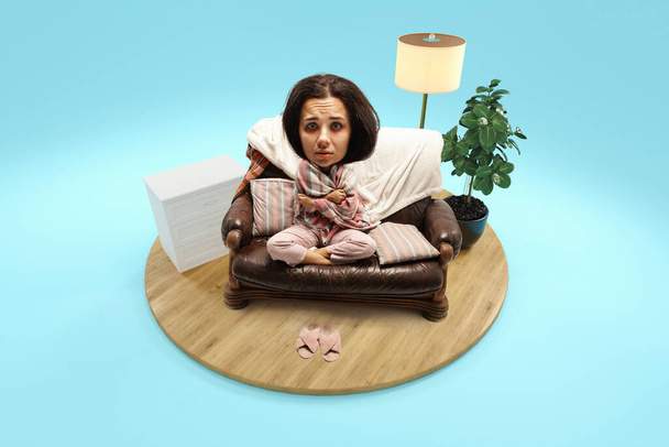 Sick woman with giant head and small body sitting on sofa covered blanket at home, in room isolated blue background. 3d-rendering island. Concept of art, emotions, quarantine, humor, allergy. Ad - Photo, Image