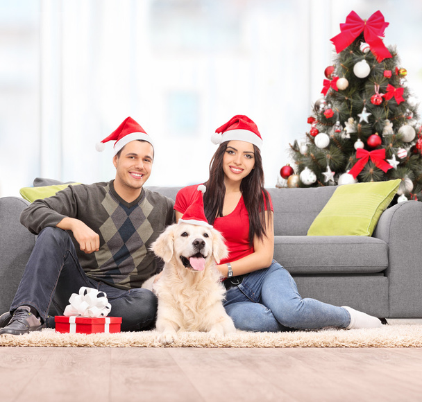 Couple celebrating Christmas with dog - Foto, afbeelding