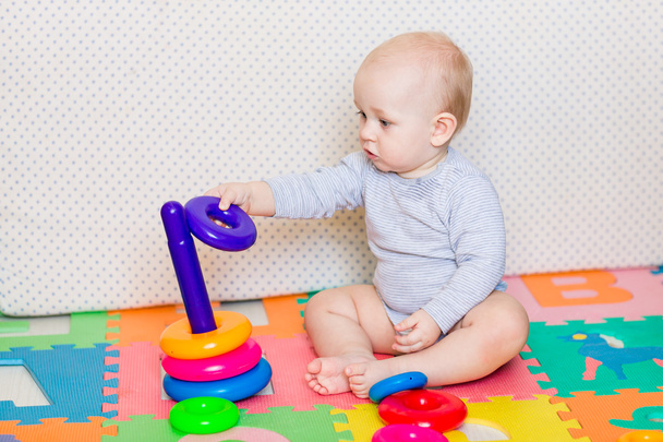 Cute little baby playing with colorful toys - Foto, Imagen