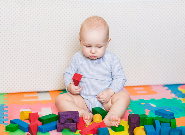 Мила маленька дитина грає з барвистими іграшками
 - Фото, зображення