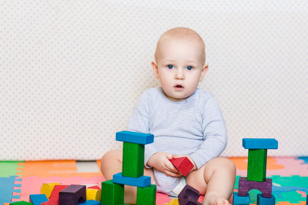 Χαριτωμένο μικρό μωρό που παίζει με τα πολύχρωμα παιχνίδια - Φωτογραφία, εικόνα
