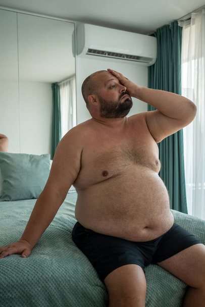 Fat guy suffers tortures from excessive sweating heat stuffiness summer abnormally high temperatures. Sweating due to obesity. Problems diseases excess weight entails diabetes knocking down hormones. - Photo, Image