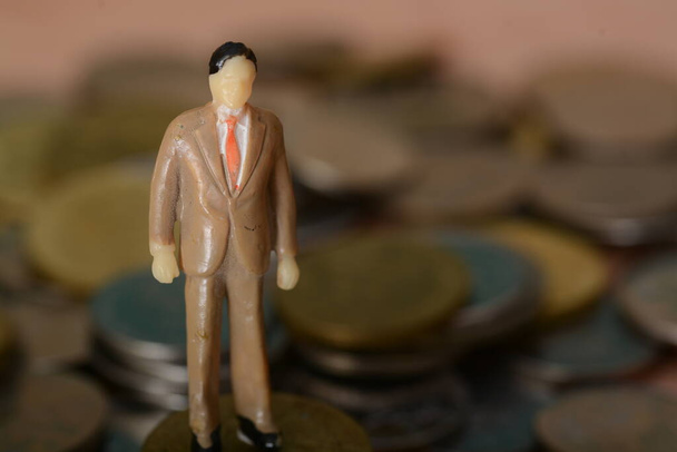 The enterprising businessman, standing atop a pile of coins,looking forward with unwavering determination, ready to seize new opportunities to success. - Photo, Image