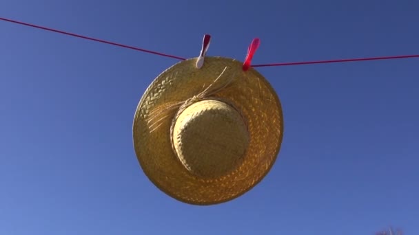 Clothes line with woman straw summer hat in wind and sky background - Footage, Video