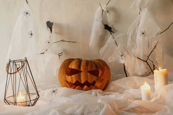 Spookachtige Jack o lantaarn gesneden pompoen, spinnenweb, geest, vleermuizen en gloeiende kaarsen in de avond. Fijne Halloween! Enge sfeervolle Halloween feestversieringen, ruimte voor tekst. Snoep of je leven - Foto, afbeelding