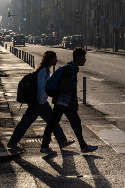 Порту, Португалия 20 сентября 2023 года Пешеходы, переходящие улицу в утреннем свете на Руа да Конститукао. - Фото, изображение