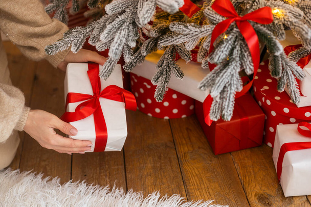 Neugierig glückliche romantische Frau, die vor dem Hintergrund des Weihnachtsbaums steht. Eine gut gelaunte Dame überraschte das Geschenk nach der Öffnung in der Geschenkbox. Frohe Weihnachten und frohe Feiertage - Foto, Bild