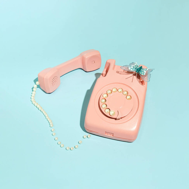 Pasztell rózsaszín vintage forgótárcsás telefon, kreatív esztétikai elrendezés. Nosztalgia inspiráció. - Fotó, kép