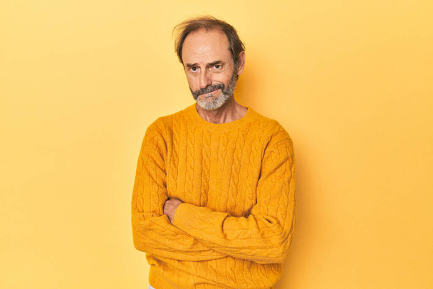Kaukázusi középkorú férfi sárga stúdióban boldogtalan nézett kamera szarkasztikus kifejezés. - Fotó, kép