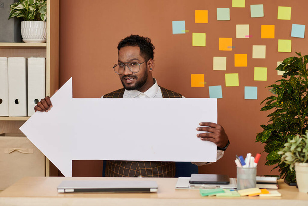 Cheerful businessman showing big paper arrow - Photo, Image