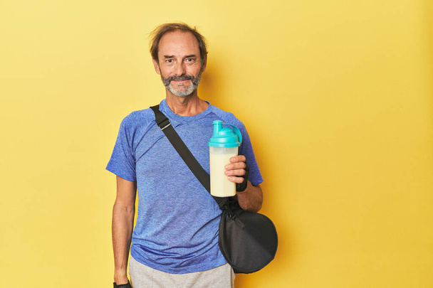 Sportowy mężczyzna z proteinowym shake 'iem i torbą sportową - Zdjęcie, obraz