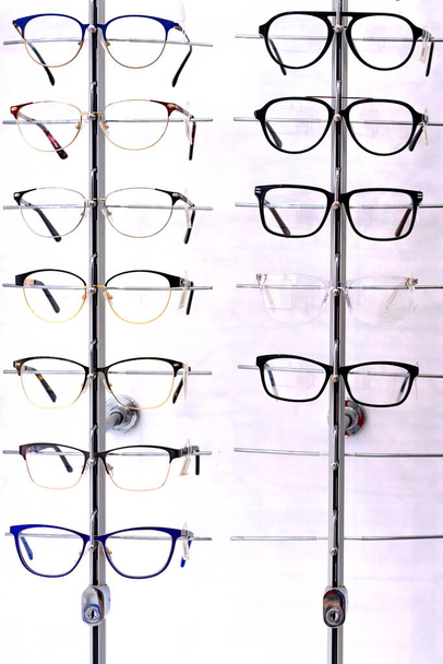 rivi lasit. Monia värisilmälaseja. Monet eri lasit hyllyillä lasikaupassa. Käsite ostaa ja kokeilla uusia laseja. sivukuva - Valokuva, kuva