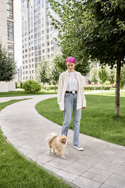 plná délka trendy fialové-vlasy žena procházky s pomeranian spitz na městské ulici, požitek - Fotografie, Obrázek