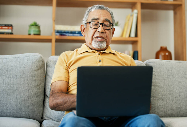 Gépelés, idős férfi és laptop kanapén otthon online kutatás a nappaliban, vagy streaming video, filmek vagy tv show. Idősek, blogolás vagy kommunikáció céljából nyugdíjba vonuló személyek vagy írók. - Fotó, kép