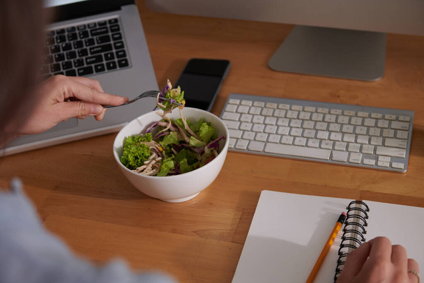 Salata yiyen ve planlamacıyla yazan bir kadın resmi. - Fotoğraf, Görsel
