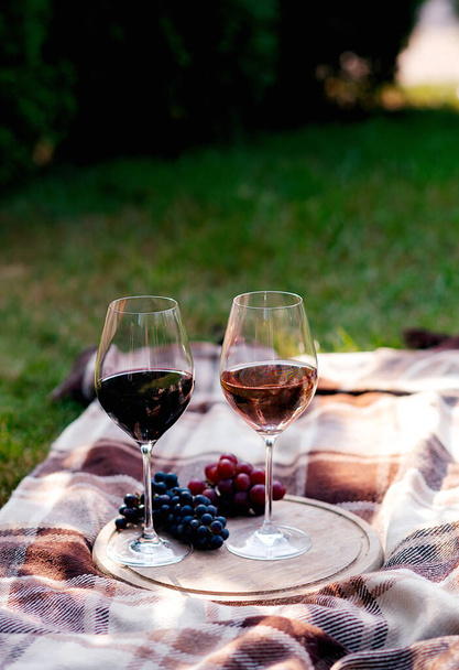 木製のテーブルにブドウの束とワインのグラス - 写真・画像