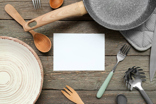 Blanko-Karte und verschiedene Küchenutensilien auf Holzgrund - Foto, Bild