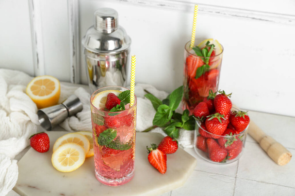 Verre de fraise fraîche mojito avec shaker et jigger sur table carrelage blanc - Photo, image