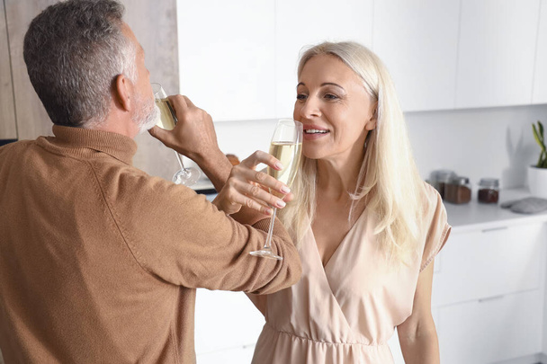 Idős pár pezsgőt iszik a konyhában - Fotó, kép