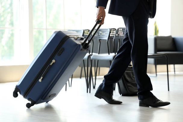 Homme d'affaires mature avec valise marchant dans le hall de l'aéroport - Photo, image