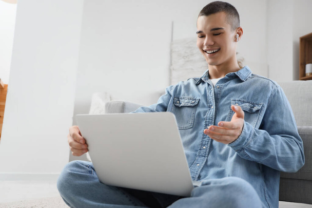 Молодий чоловік з ноутбуком відео балачки вдома
 - Фото, зображення