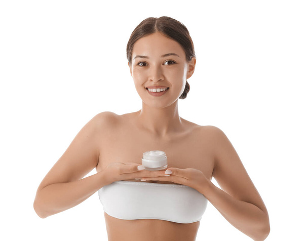 Mooie Aziatische vrouw met pot crème op witte achtergrond, close-up - Foto, afbeelding