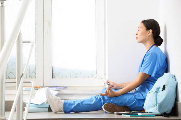 Aasian lääketieteellinen harjoittelija meditointi portaissa yliopistossa - Valokuva, kuva