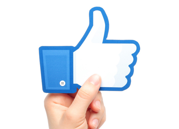 Hand holds facebook thumbs up sign - Foto, imagen