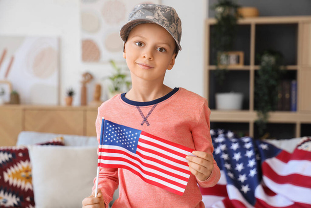 Niño con gorra militar y bandera de los Estados Unidos en casa. Celebración del Día de los Veteranos - Foto, imagen
