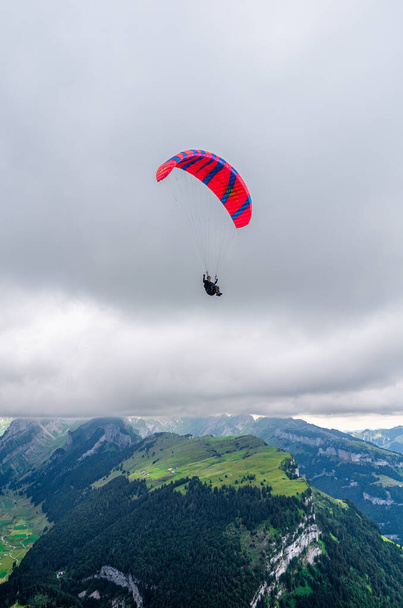Altstatten, Svizzera - 4 luglio 2023: Un parapendio circonda la cima della montagna Hoher Kasten - Foto, immagini