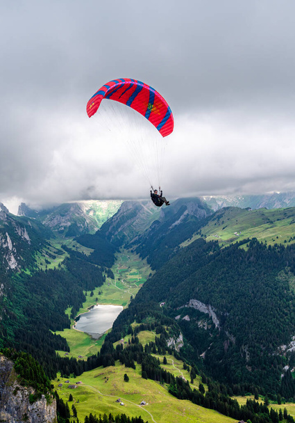Altstatten, Schweiz - 4. Juli 2023: Ein Gleitschirm umkreist den Gipfel des Hohen Kasten - Foto, Bild