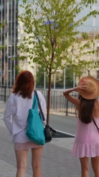 En medio del paisaje urbano, dos jóvenes enérgicas con equipaje y bolsos se abren paso por las calles. Imágenes de alta calidad 4k - Imágenes, Vídeo